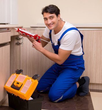 Mutfakta çalışan genç tamirci.