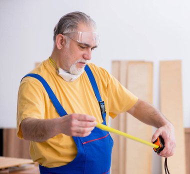 Atölyede çalışan yaşlı erkek marangoz.