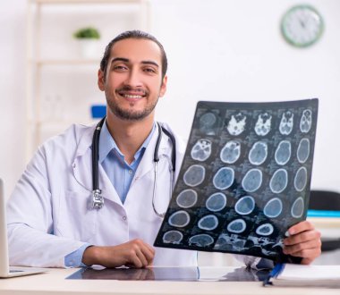 Klinikte çalışan yakışıklı genç bir doktor.