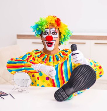Erkek palyaço evde performansa hazırlanıyor.