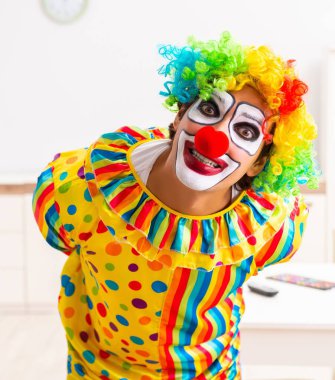 Erkek palyaço evde performansa hazırlanıyor.