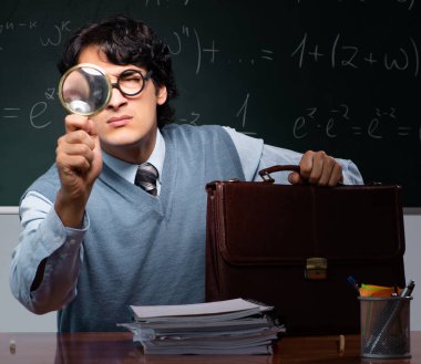 Tahtanın önündeki genç matematik öğretmeni.