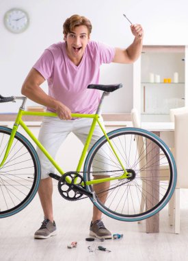 Kırık bisikletini tamir eden adam.