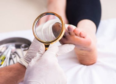 Doktor travmatoloğu ziyaret eden yaralı bir kadın.