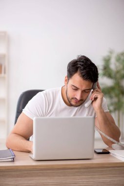 Genç çalışan işyerinde oturuyor.