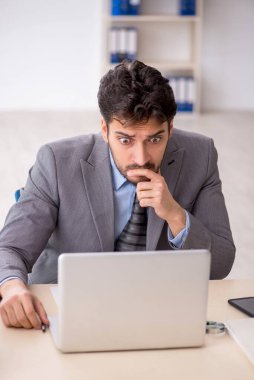 Genç bir çalışan ve ofiste çok fazla iş var.