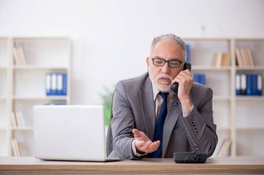 Eski bir çalışan iş yerinde telefonla konuşuyor.