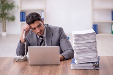 Genç bir çalışan ve ofiste çok fazla iş var.