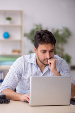 Genç çalışan işyerinde oturuyor.