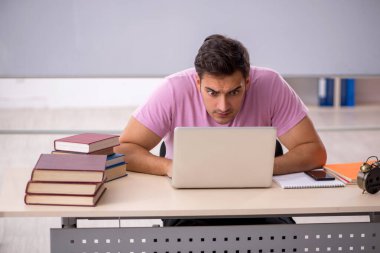 Sınıfta sınava hazırlanan genç bir öğrenci.