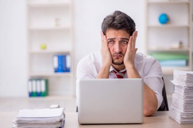 Ofisteki aşırı işten memnun olmayan genç bir çalışan.