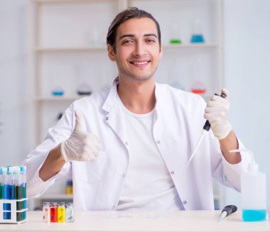 Laboratuvarda çalışan genç erkek kimyager.