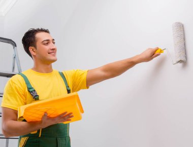 Duvarı sönük konseptle boyayan adam.