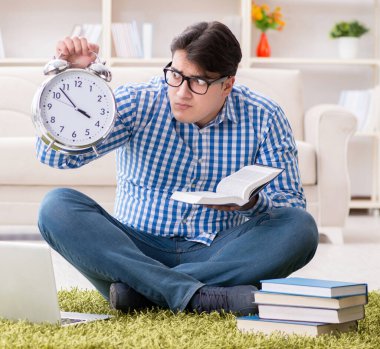 Genç yakışıklı adam evde yerde oturuyor.