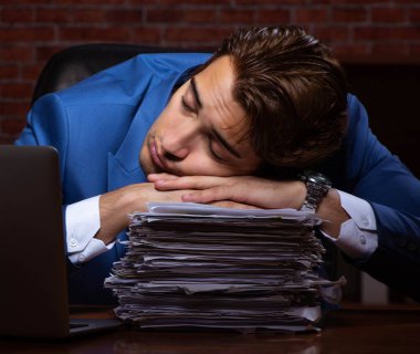 Geceleri ofiste çalışan genç işadamı.