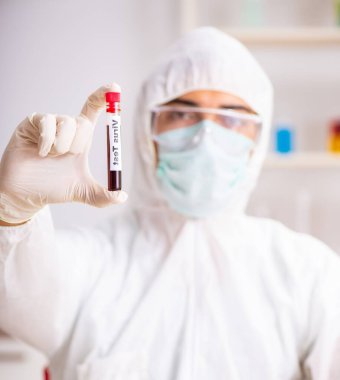 Genç yakışıklı laboratuvar asistanı hastanede kan örneklerini test ediyor.