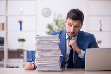 Genç bir çalışan ve ofiste çok fazla iş var.