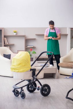 Yeni doğan bebeğe bakan genç bir müteahhit.