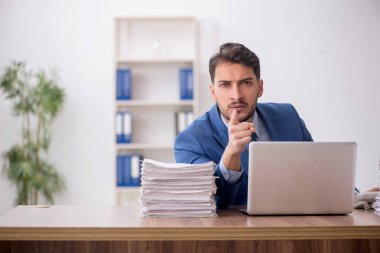 Young employee and too much work at workplace