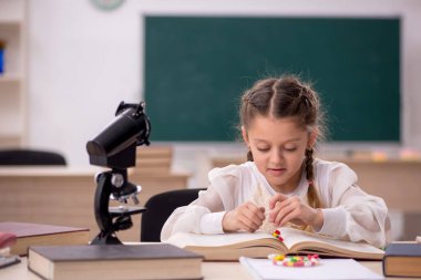 Little girl in drugs synthesis concept in the classroom