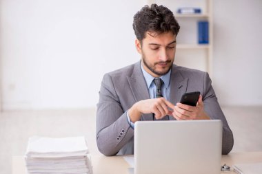 Genç bir çalışan ve ofiste çok fazla iş var.