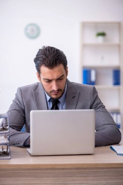 Genç bir çalışan ve ofiste çok fazla iş var.