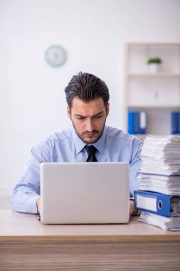 Genç bir çalışan ve ofiste çok fazla iş var.