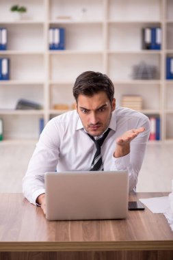 Genç işadamı işyerinde oturuyor.