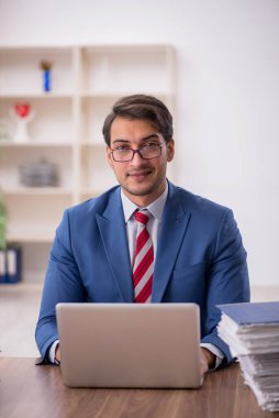 Genç işadamı işyerinde oturuyor.