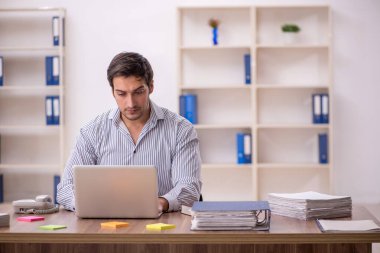 Genç işadamı işyerinde oturuyor.