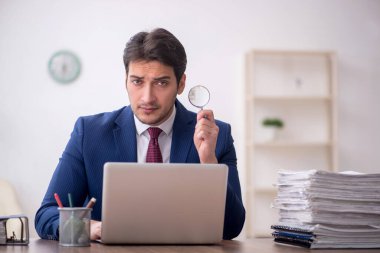 Genç bir çalışan ve ofiste çok fazla iş var.