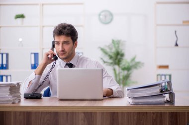 Young employee and too much work at workplace