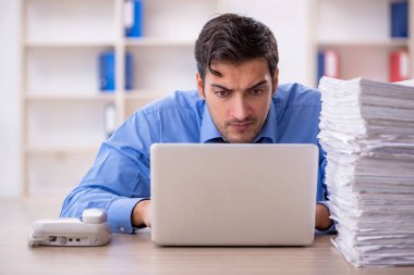 Genç işadamı ve ofiste çok fazla iş var.