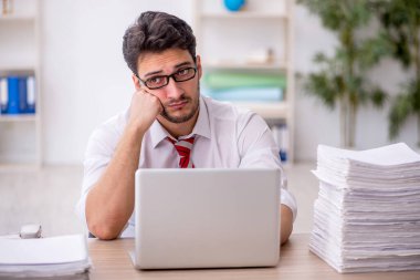 Ofisteki aşırı işten memnun olmayan genç bir çalışan.