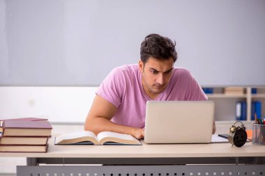 Sınıfta sınava hazırlanan genç bir öğrenci.