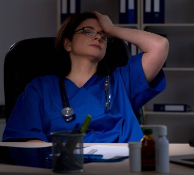 Gece vardiyasında çalışan yaşlı kadın doktor.