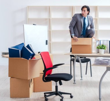 Ofiste kutuları olan genç adam.