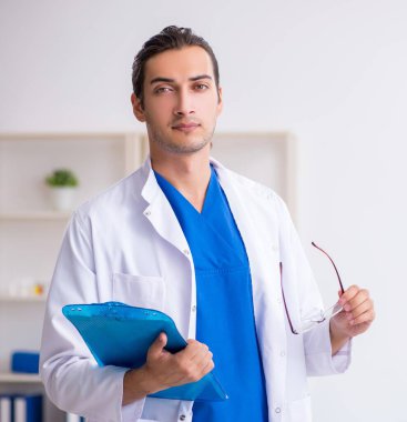 Klinikte çalışan genç erkek doktor.