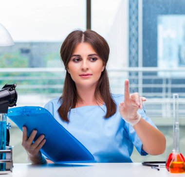 Laboratuvarda düğmelere basan genç kadın.