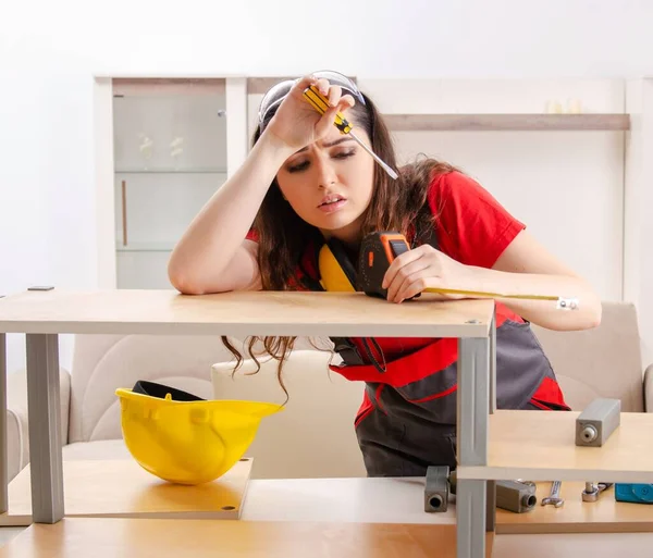 The female contractor repairing furniture at home