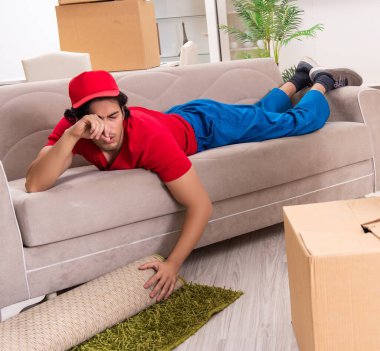 İçeride çalışan kutularla çalışan genç bir erkek müteahhit.