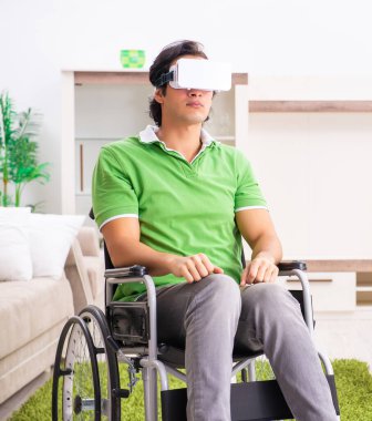 The young handsome man in wheelchair at home