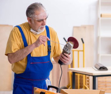 Atölyede çalışan yaşlı erkek marangoz.