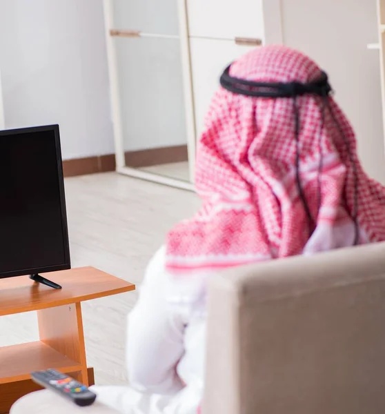 The arab businessman watching tv at home