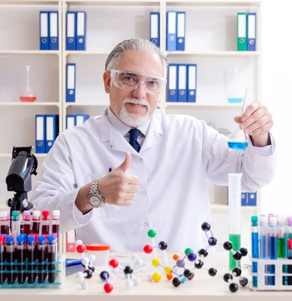 The old male chemist working in the lab