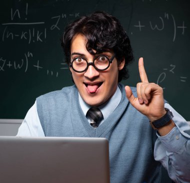 Tahtanın önündeki genç matematik öğretmeni.