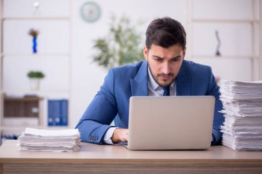 Genç bir çalışan ve ofiste çok fazla iş var.