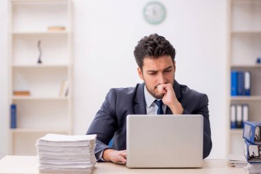 Genç bir çalışan ve ofiste çok fazla iş var.