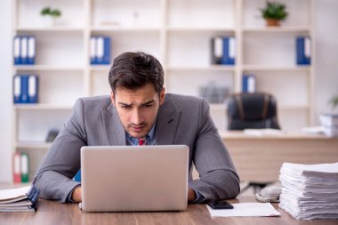 Genç işadamı işyerinde oturuyor.