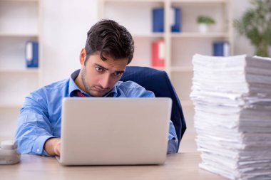 Genç işadamı ve ofiste çok fazla iş var.